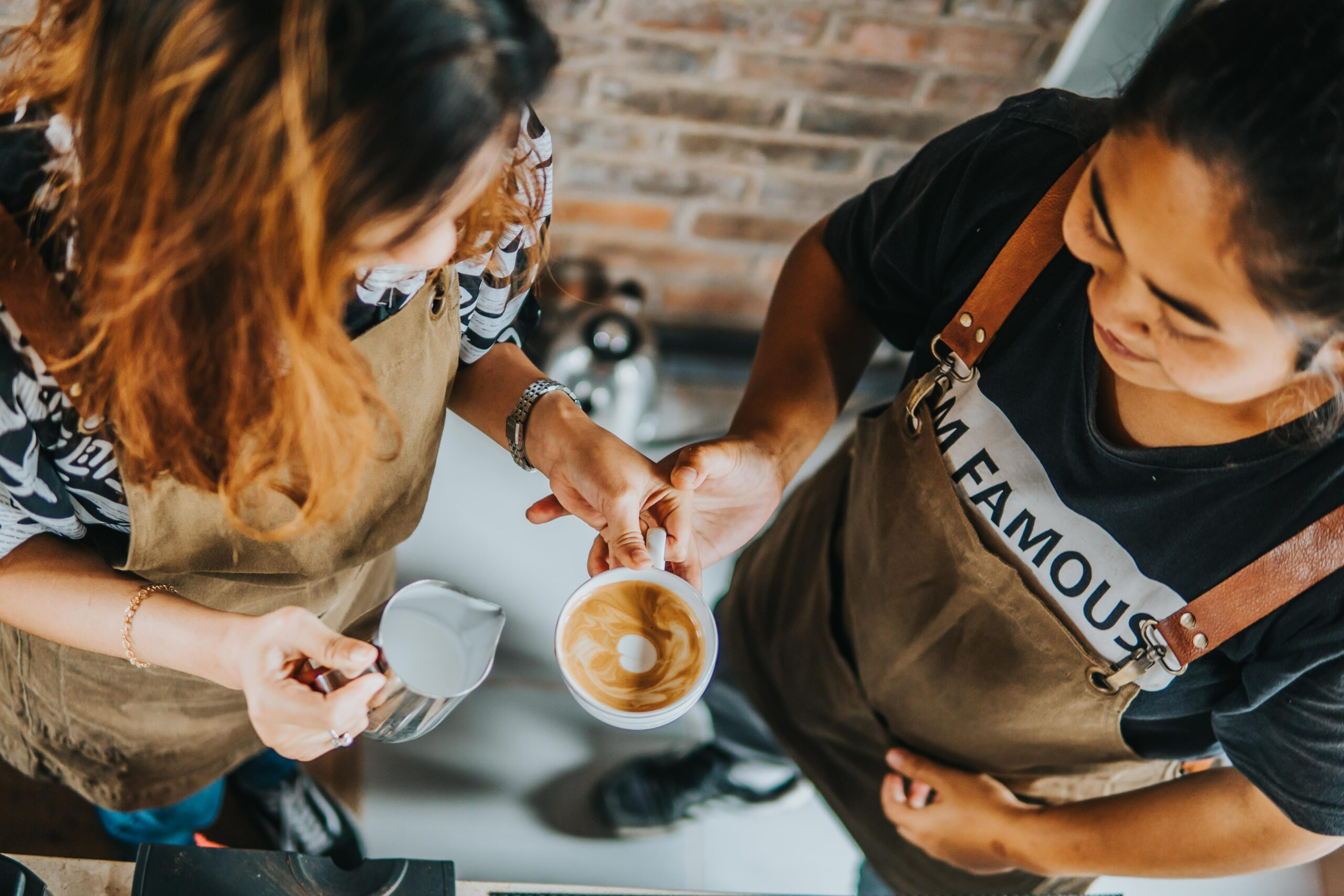 two girls, one barista serving coffee
