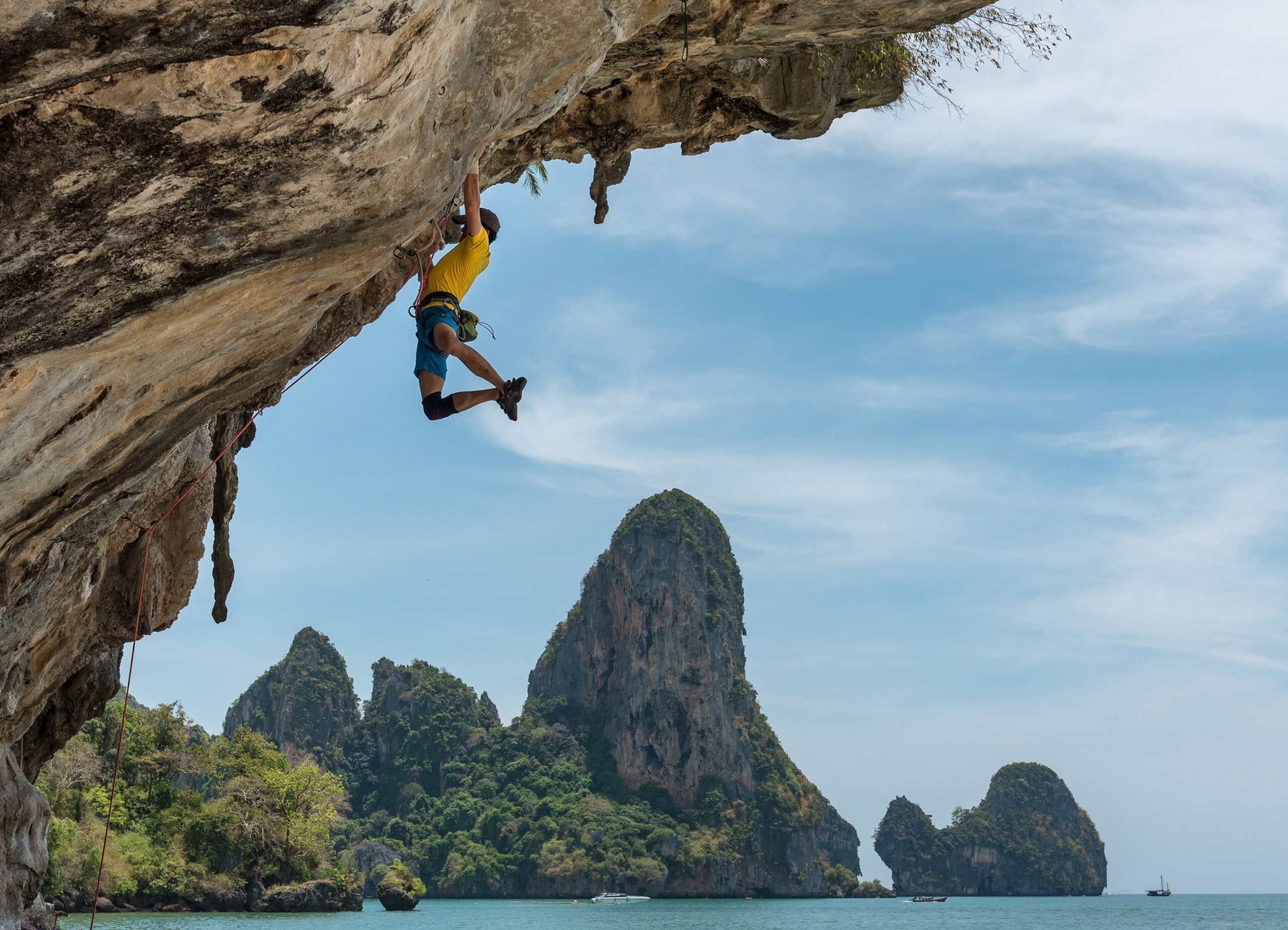 man rock climbing in tonsai beach, thailand