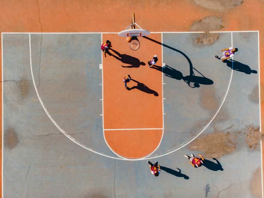 basketball players on orange and grey court